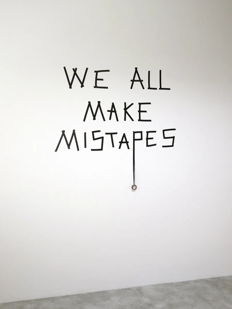 mistapes, the words on the wall with the roll of tape hanging below