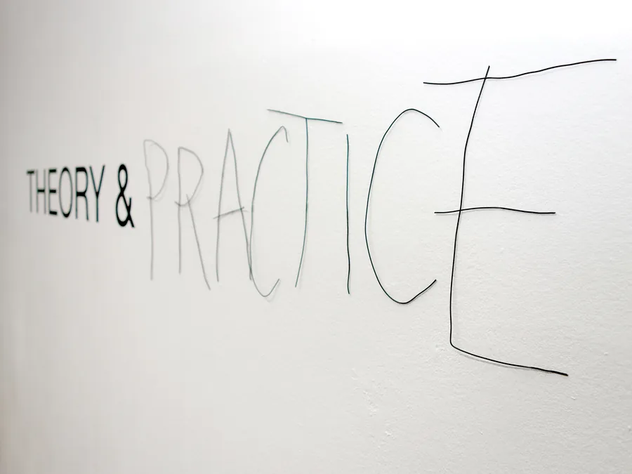 theory & practice, seen from the side, the drawn half of the word coming loose