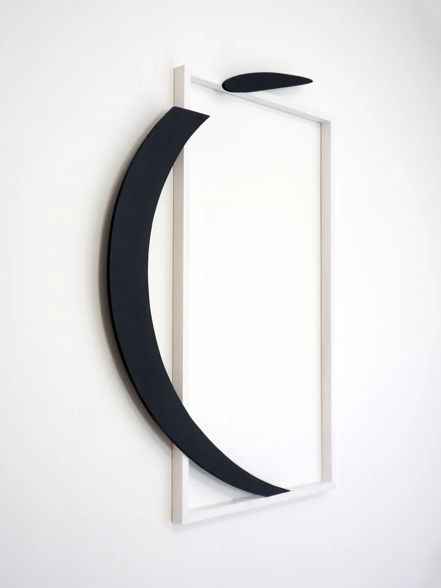i bent out of shape, seen from the side, the bent letter standing off the frame